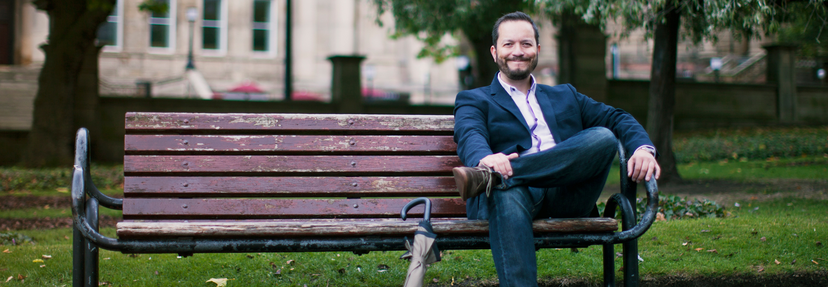 Photograph of Colin Scotland sitting on a park bench